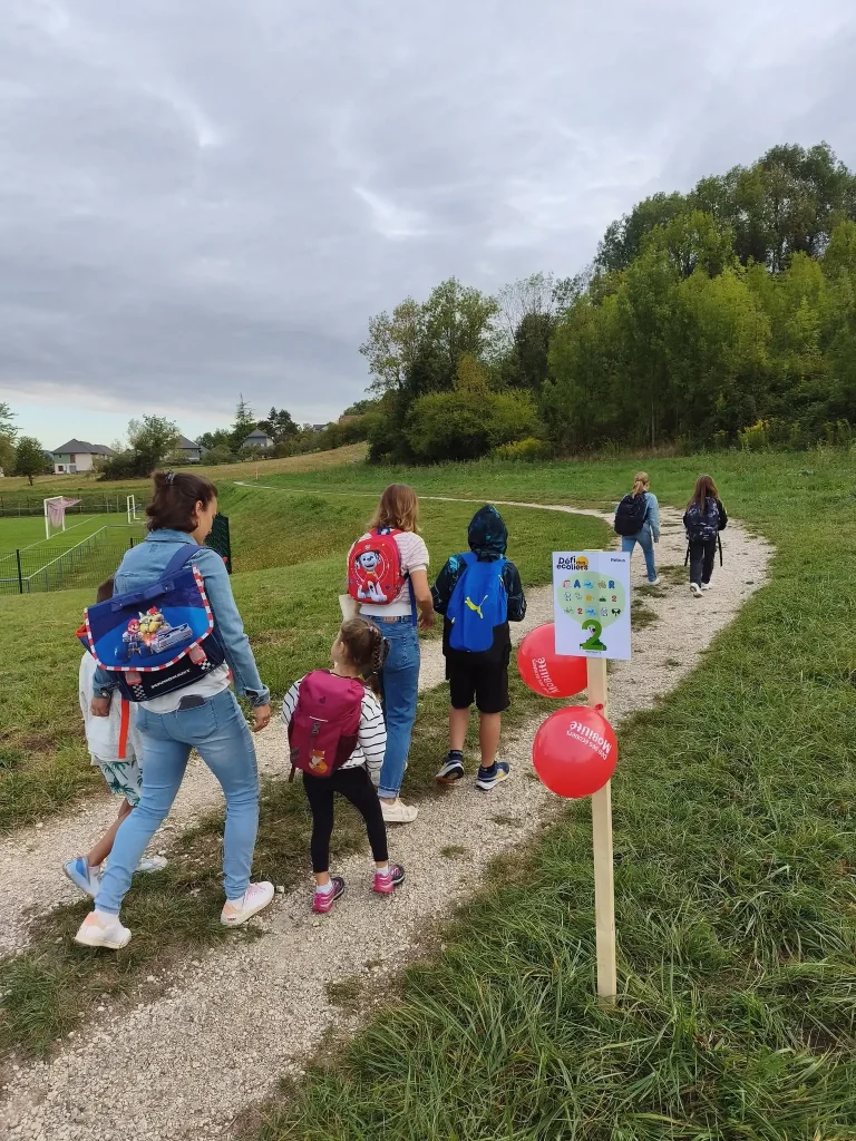 Enfants et parents qui marchent sur un chemin du défi des écoliers